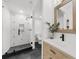 Modern bathroom features walk-in shower with a geometric pattern and wood vanity at 1358 Peppergrass Nw Trl, Acworth, GA 30101