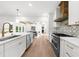 Modern white kitchen boasts stainless steel appliances, white cabinets and wood floors at 1358 Peppergrass Nw Trl, Acworth, GA 30101