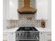 Close-up of modern kitchen with stainless steel range and white cabinets with gold hardware at 1358 Peppergrass Nw Trl, Acworth, GA 30101