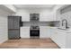 Kitchen features white cabinets, stainless steel appliances, and modern countertops at 1358 Peppergrass Nw Trl, Acworth, GA 30101