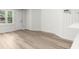 A bright and spacious room with wood paneling, new floors and a large window at 1358 Peppergrass Nw Trl, Acworth, GA 30101