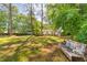 Serene backyard featuring a rustic bench and lush green lawn, perfect for relaxation at 3294 Mcclure Bridge Rd, Duluth, GA 30096