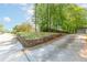 Wide driveway leading to a home, bordered by stone retaining wall and mature trees at 3294 Mcclure Bridge Rd, Duluth, GA 30096