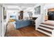 Open living space features a blue couch, wooden floors, fireplace, stairs, and open concept kitchen at 3294 Mcclure Bridge Rd, Duluth, GA 30096