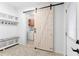 Mud room with custom shelving, a sliding barn door, and tile floors, offering a practical entryway at 3294 Mcclure Bridge Rd, Duluth, GA 30096