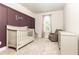 Charming Bedroom with purple accent wall, white furniture set, including crib, glider and dresser at 500 Garvin Dr, Woodstock, GA 30189