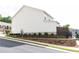 View of the home exterior with a stone foundation, black metal fence and manicured lawn at 500 Garvin Dr, Woodstock, GA 30189