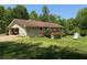 Spacious backyard with lush lawn, a detached garage, and a small deck on the house at 7260 Cox Rd, Cumming, GA 30028