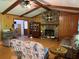 Spacious living room with a stone fireplace, beamed ceiling, and wood paneled walls at 7260 Cox Rd, Cumming, GA 30028