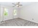 This bedroom has neutral walls, carpet flooring, a ceiling fan and two windows at 1463 Shadowrock Hts, Marietta, GA 30062