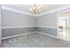 Open dining room area with gray walls, carpet, chandelier, and access to kitchen at 1463 Shadowrock Hts, Marietta, GA 30062