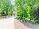 Secluded two-story home with an elongated driveway leading to an attached two-car garage amid a lush wooded landscape at 1463 Shadowrock Hts, Marietta, GA 30062