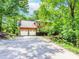 Charming two-story brick home featuring a spacious driveway and a two-car garage surrounded by lush trees at 1463 Shadowrock Hts, Marietta, GA 30062