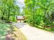 Secluded two-story home with an elongated driveway leading to an attached two-car garage amid a lush wooded landscape at 1463 Shadowrock Hts, Marietta, GA 30062