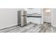 Basement kitchenette features stainless steel refrigerator, white cabinets, dark counters, and wood-look flooring at 1463 Shadowrock Hts, Marietta, GA 30062