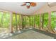 Sunroom featuring walls of screened windows with wooded views, door to the exterior, ceiling fan and indoor carpet at 1463 Shadowrock Hts, Marietta, GA 30062