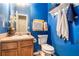 Vibrant powder room with bright blue walls and decorative towels at 436 Berkshire Pl, Fairburn, GA 30213
