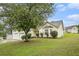 Well-manicured front yard featuring a large tree, green grass, and tastefully trimmed bushes at 436 Berkshire Pl, Fairburn, GA 30213