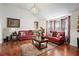 Inviting living room with hardwood floors, vaulted ceiling and plush red sofas and decor at 436 Berkshire Pl, Fairburn, GA 30213