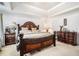 Comfortable main bedroom with dark wood furnishings and a tray ceiling at 436 Berkshire Pl, Fairburn, GA 30213