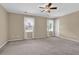 Spacious bedroom with neutral carpet, ceiling fan, and ample natural light through the windows at 6139 Keswick Row, Tucker, GA 30084