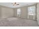 Spacious bedroom with neutral carpet, ceiling fan, and ample natural light from the windows at 6139 Keswick Row, Tucker, GA 30084