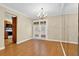 Bright dining room featuring hardwood floors, chandelier, and French doors with floral curtains at 6139 Keswick Row, Tucker, GA 30084