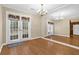Bright dining room features a chandelier, hardwood floors, and access to the outdoors through French doors at 6139 Keswick Row, Tucker, GA 30084