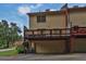 Back of tan townhome featuring a wooden deck and covered parking at 6139 Keswick Row, Tucker, GA 30084