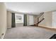 Spacious living room with neutral carpet, staircase, and ample natural light at 6139 Keswick Row, Tucker, GA 30084