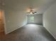 Spacious bedroom with ceiling fan, plush carpeting, a window, and neutral color scheme at 25 Emerald Ln, Covington, GA 30014