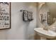 Well-lit bathroom with a pedestal sink, round mirror, and decorative wall art at 5800 Oakdale Se Rd # 147, Mableton, GA 30126
