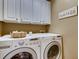 Laundry room includes front load washer and dryer with upper cabinets at 5800 Oakdale Se Rd # 147, Mableton, GA 30126