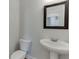 Well-lit bathroom featuring a pedestal sink and a framed mirror on a neutral wall at 1258 Ainsworth Aly # 46, Sugar Hill, GA 30518