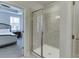 Primary bathroom featuring a glass enclosed tile shower, in a bedroom with tray ceiling at 1258 Ainsworth Aly # 46, Sugar Hill, GA 30518