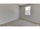 This carpeted bedroom has a window and neutral-toned walls at 1258 Ainsworth Aly # 46, Sugar Hill, GA 30518