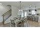 View of dining room, kitchen, and staircase with modern lighting fixtures and wood floors at 1258 Ainsworth Aly # 46, Sugar Hill, GA 30518