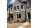 Charming townhome with brick facade, covered entry, and landscaped front yard at 1258 Ainsworth Aly # 46, Sugar Hill, GA 30518