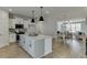 Open-concept kitchen features an island with granite countertops, white cabinets, and wood flooring at 1258 Ainsworth Aly # 46, Sugar Hill, GA 30518