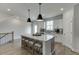 Open-concept kitchen with island seating, pendant lighting, and a seamless flow to the living area at 1258 Ainsworth Aly # 46, Sugar Hill, GA 30518
