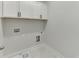 A laundry room is bright with white cabinets and hookups at 1258 Ainsworth Aly # 46, Sugar Hill, GA 30518