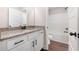 Bright bathroom with granite countertops, white cabinets, wood look flooring, and a shower-tub combo at 1874 Mcgarity Rd, Mcdonough, GA 30252