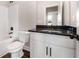 Well-lit bathroom featuring black granite countertop, white cabinets, toilet, and a shower-tub combo at 1874 Mcgarity Rd, Mcdonough, GA 30252