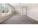 Bright, carpeted bedroom showcasing natural light through its large window and a closet at 1874 Mcgarity Rd, Mcdonough, GA 30252