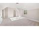 Carpeted bedroom under a dormered ceiling, featuring large windows and a closet at 1874 Mcgarity Rd, Mcdonough, GA 30252