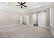 Large bedroom with tray ceiling and fan, with doors to bathroom and closet at 1874 Mcgarity Rd, Mcdonough, GA 30252
