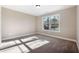 Bedroom features neutral walls, carpet, and a large window with natural light at 1874 Mcgarity Rd, Mcdonough, GA 30252