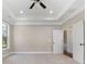 Spacious bedroom with tray ceiling and staircase access visible through doorway at 1874 Mcgarity Rd, Mcdonough, GA 30252