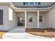 Charming front porch showcasing a brick facade with white columns, and a well-lit entryway to a welcoming home at 1874 Mcgarity Rd, Mcdonough, GA 30252