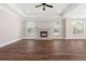 Bright living room features a brick fireplace, tray ceiling with fan, recessed lights, and dark hardwood floors at 1874 Mcgarity Rd, Mcdonough, GA 30252